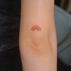 Micro rainbow tattoo